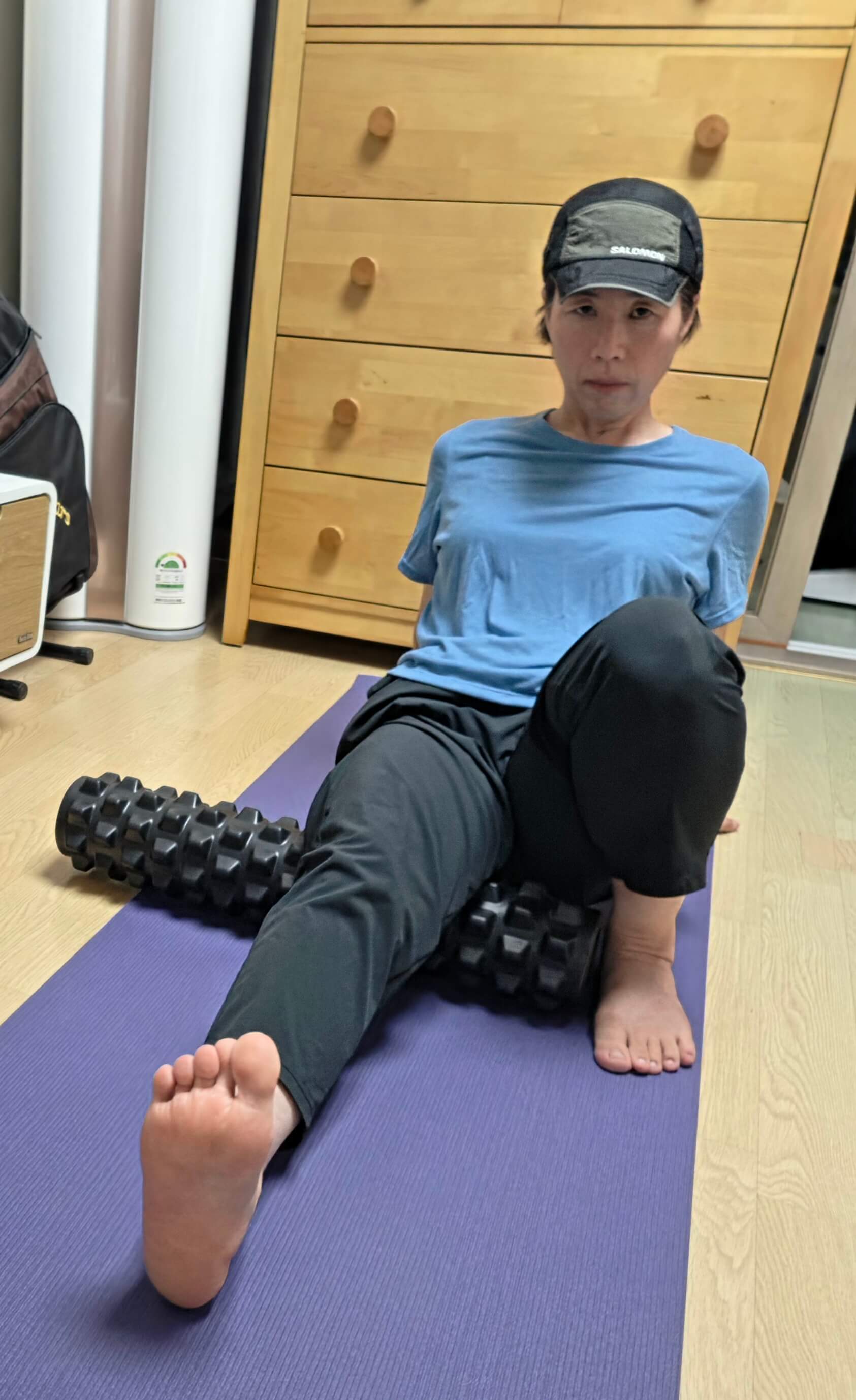 러닝 후 실내에서 폼롤러로 근막이완을 하는 모습