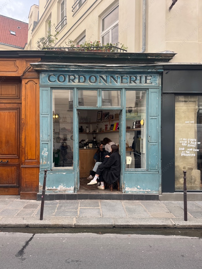 The iconic blue vintage storefront of Boot Cafe in Paris with the old Cordonnerie signboard ❘ La devanture bleue vintage du Boot Café à Paris