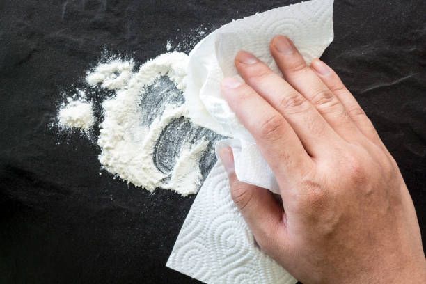 옷에 새로 묻은 기름때 위에 밀가루를 뿌려 기름을 흡수시키는 응급처치 모습