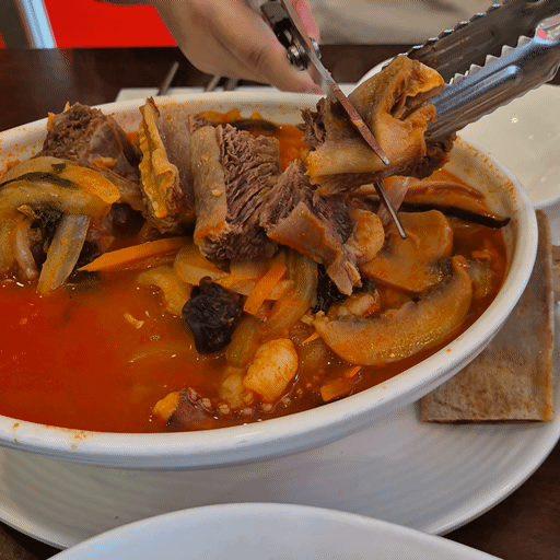 을왕리 양자강에서 주문한 왕갈비짬뽕&amp;#44; 큼직한 갈비를 가위로 자르고 있는 장면