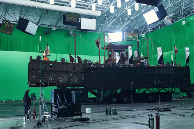 영화 노량- 초록색 배경 앞 배모양 세트에서 연기중인 배우들