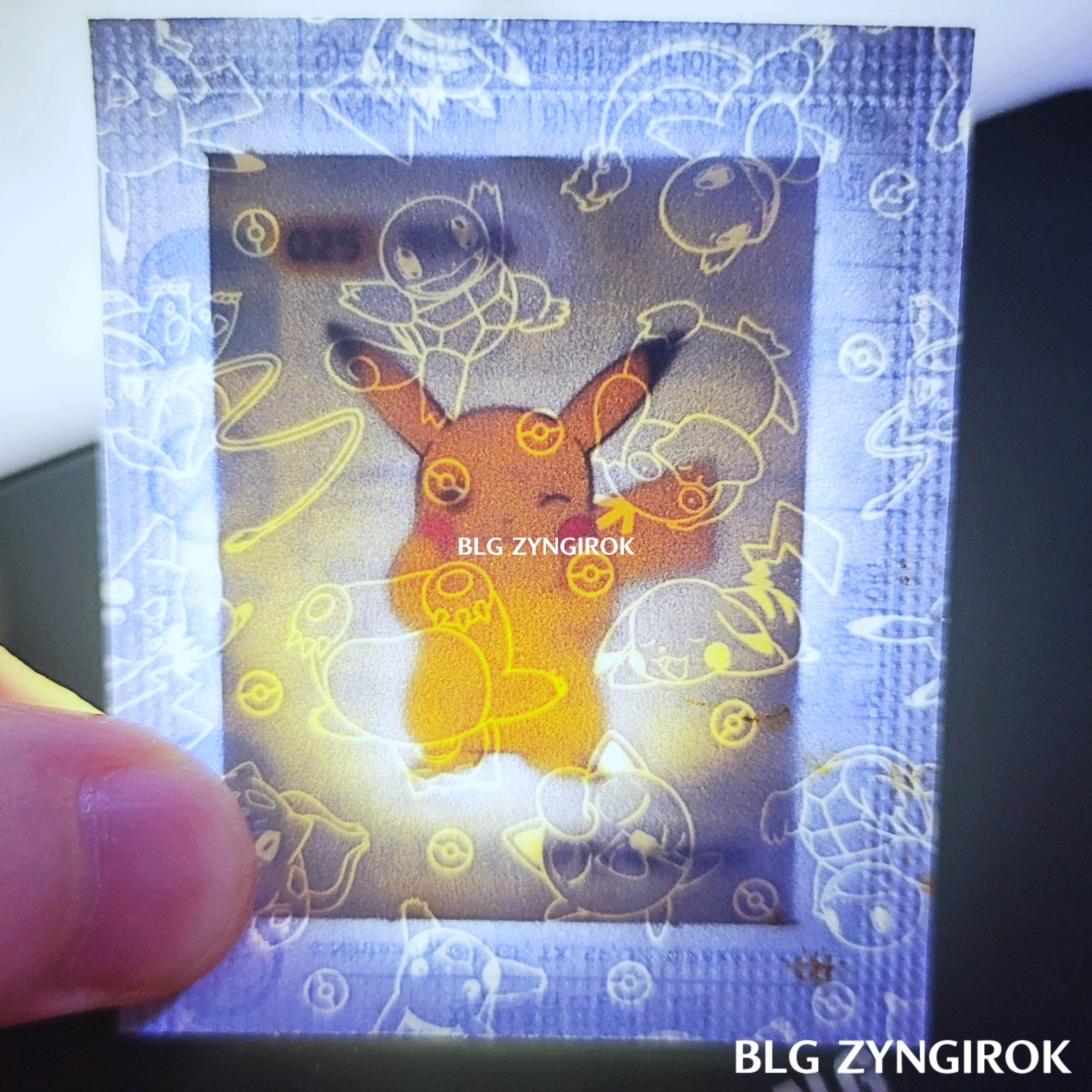 띠부띠부씰-서있는-피카츄를-들고있다.