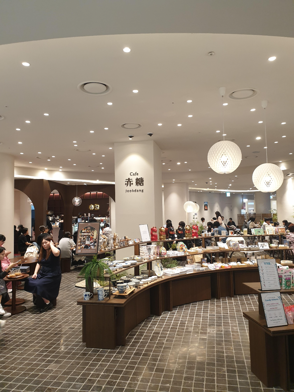 흰 기둥과 높은 천고. 앞쪽에는 굿즈 판매대가 보인다.