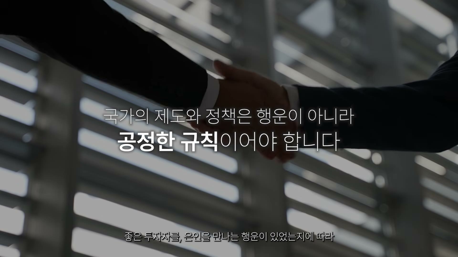 악수하는 손 위로 '국가의 제도와 정책은 행운이 아니라 공정한 규칙이어야 합니다'라는 자막