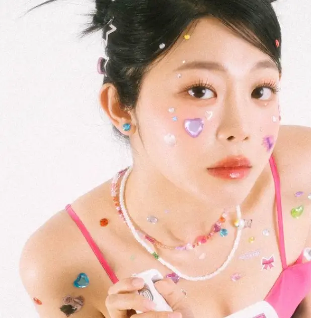 솔로지옥 3- 머리를 뒤 윗쪽 하나로 묶고 하늘색 귀걸이 흰색 플라스틱 목걸이 분홍색 끈이 달린 나시티를 입고 무표정한 얼굴로 왼쪽 위를 보고있는 최혜선