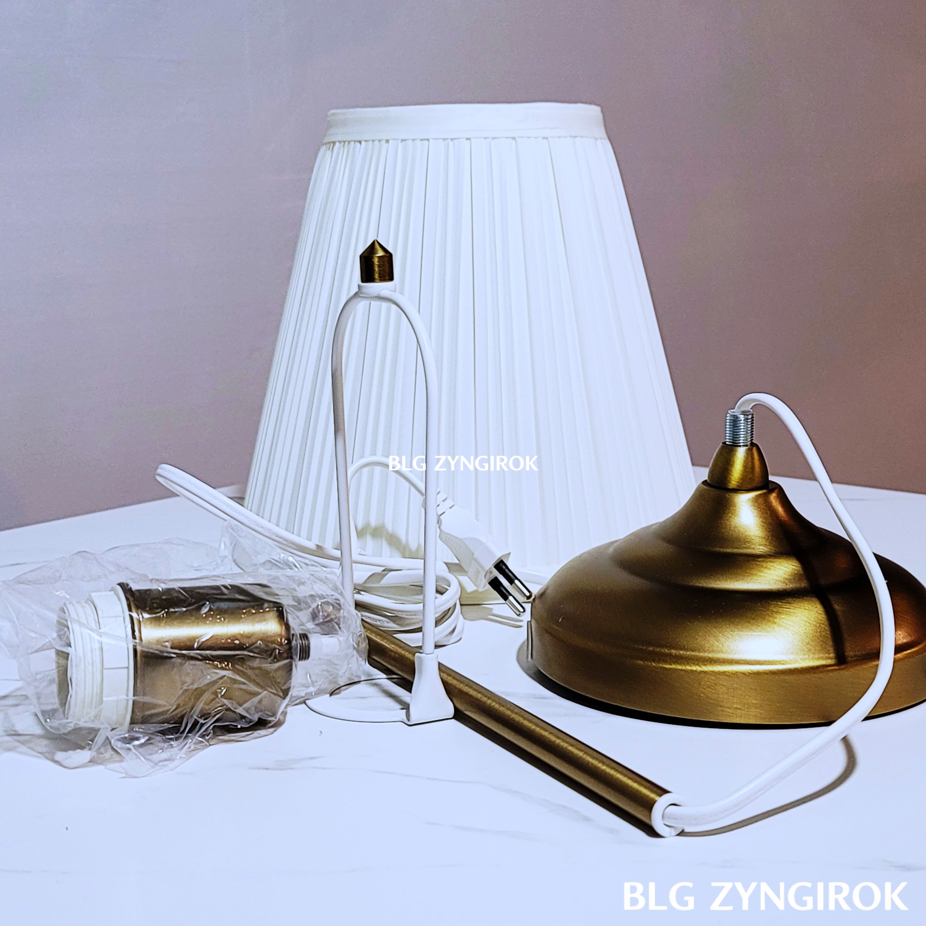 이케아-아스트리드-조명-본체이다.-조럽이-완성되지-않은-부품들이-테이블위에-놓여있다.