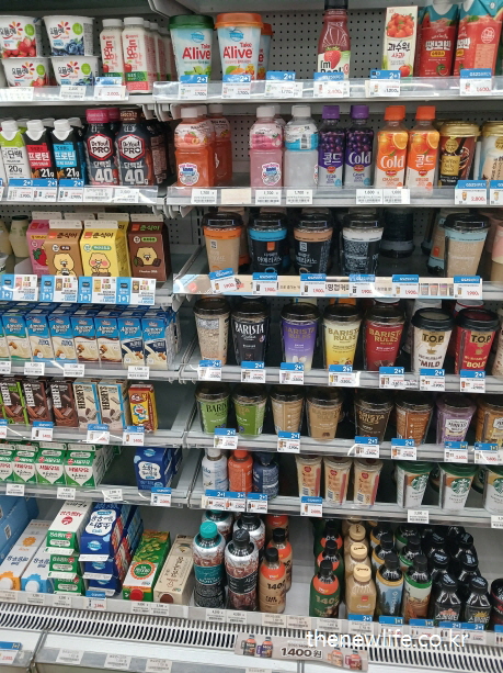 A refrigerated drink shelf in a Korean convenience store displaying various sugar-containing beverages, including coffee, fruit juice, yogurt drinks, and sports drinks.-한국 편의점 음료 진열대. 커피, 과일주스, 요거트 음료, 스포츠 음료 등 다양한 당 함유 음료가 진열되어 있다.