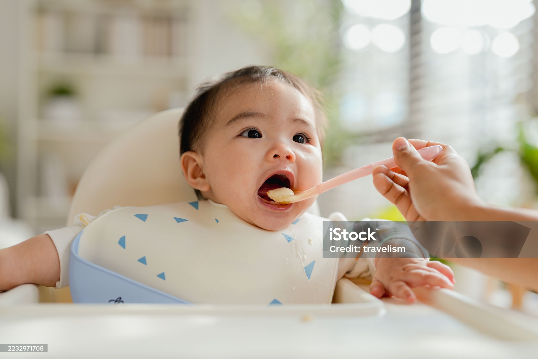 아이가 이유식을 받아 먹고 있는 사진