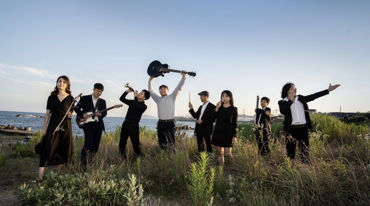 토다의 맴버들이 야외해서 음악을 연주하는 모습의 사진입니다.