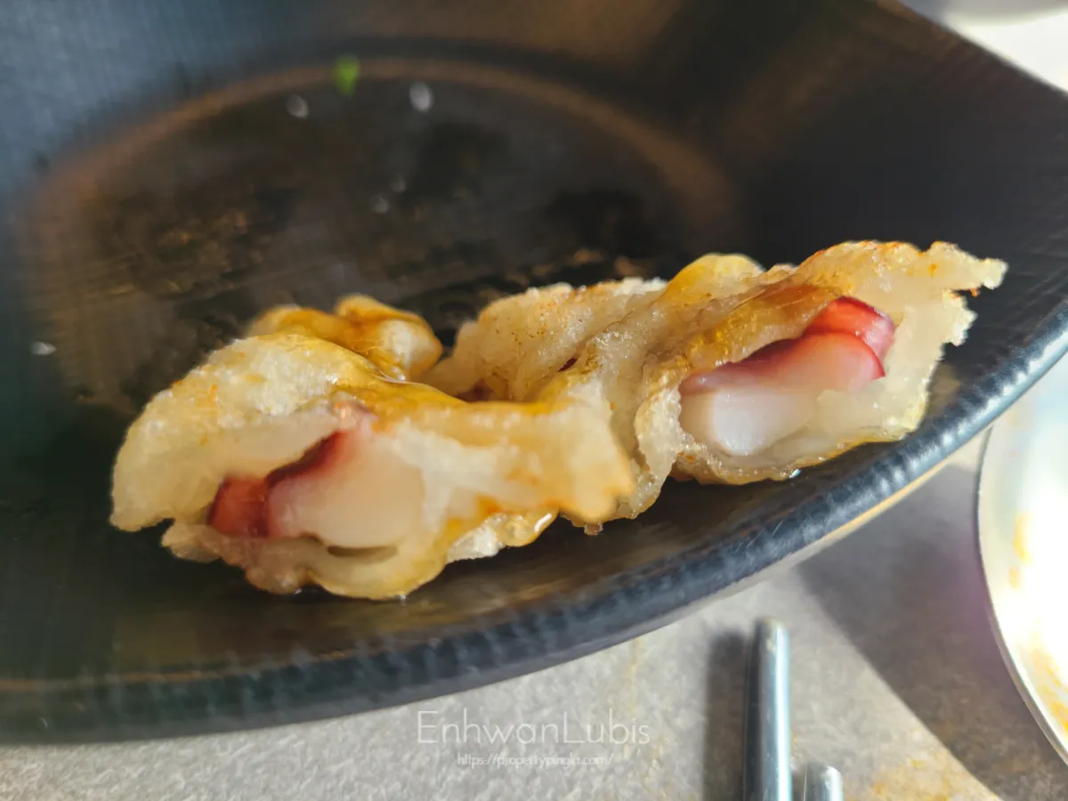 검은색-앞접시에-올려진-반잘린-문어탕수육-튀김옷-안에-문어가-보이는