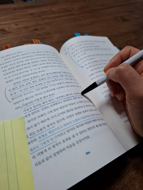 해킹 더 매트릭스 책 여백에 볼펜으로 핵심 내용을 메모하며 깊이 사유하는 모습 (A person deeply contemplating and writing notes with a ballpoint pen in the margins of the book 'Hacking the Matrix')