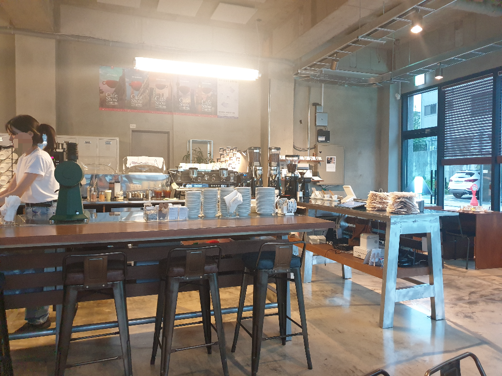 인더스트리얼 한 인테리어와 우드 테이블. 중앙은 바 테이블 형식