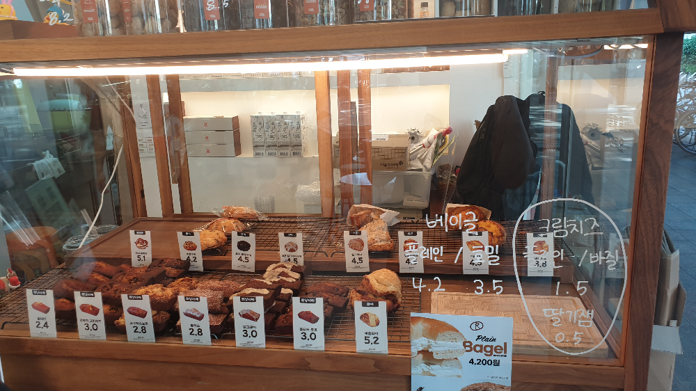 우드 프레임에 유리 쇼케이스 안에 여러가지 베이커리가 놓여있다.