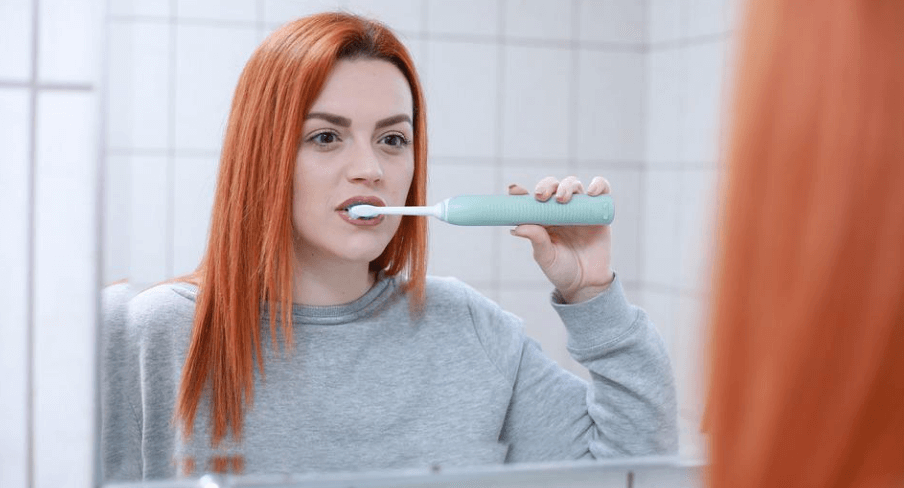 아름다운 여성이 거울을 보면서 이를 닦고 있다