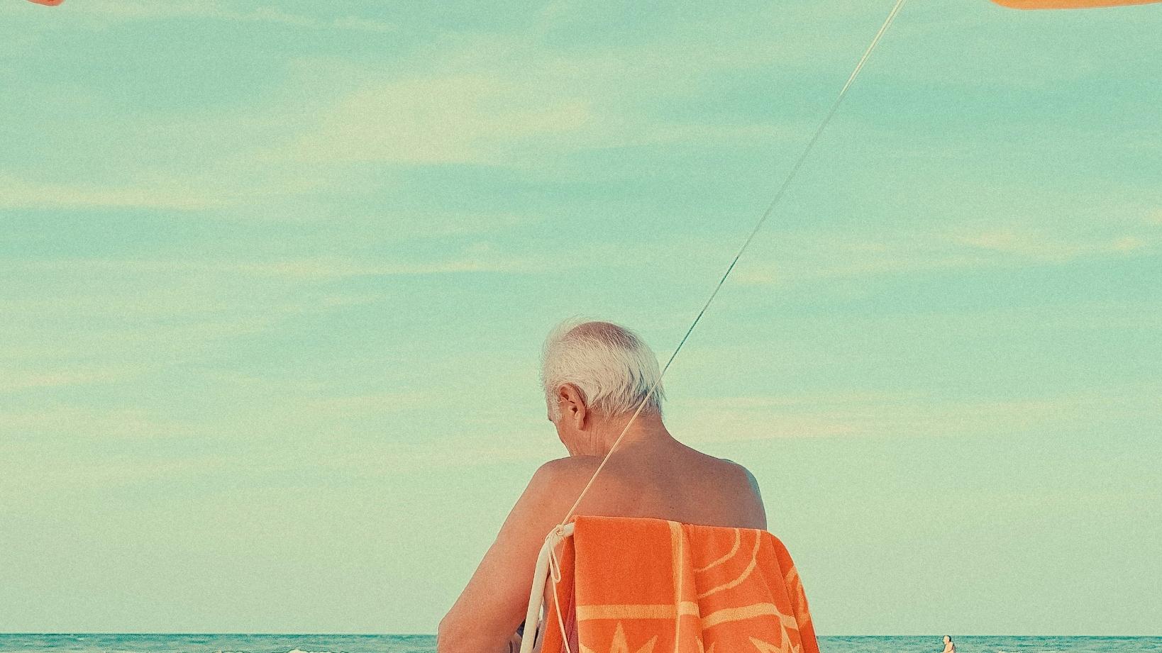 시니어 열사병과 일사병 예방을 위해 해변에서 낚시하는 남성의 뒷모습