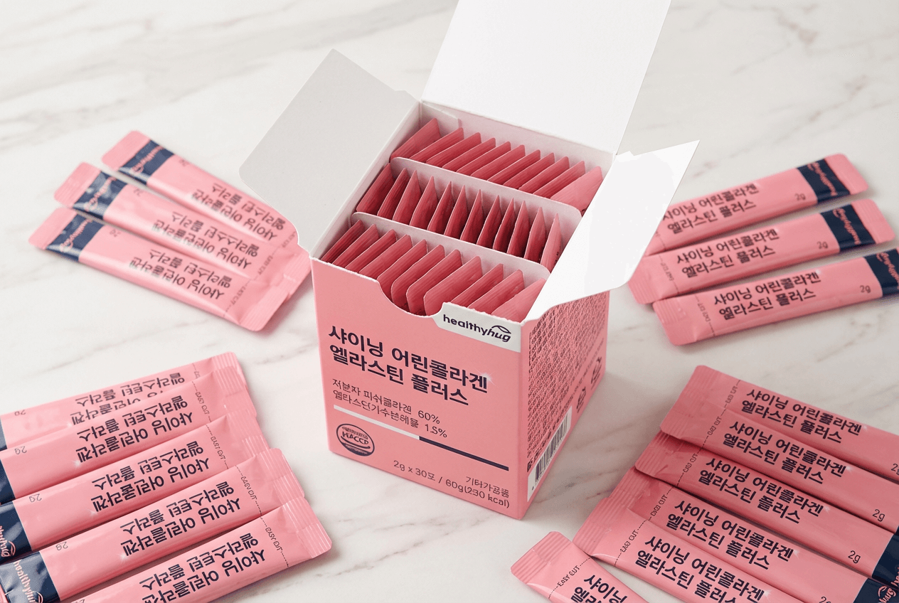 핑크색 스틱형 분말 제품 ‘샤이닝 어린콜라겐 엘라스틴 플러스’ 박스 개봉 모습과 개별 스틱 포장이 놓인 제품 사진