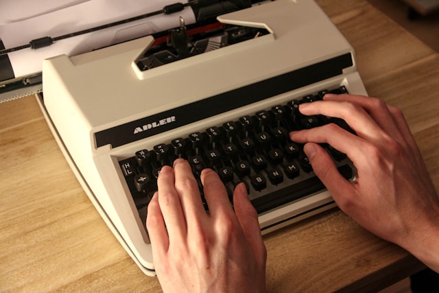 타자기를 두드리는 사람의 손, 글쓰기 습관을 상징하는 이미지