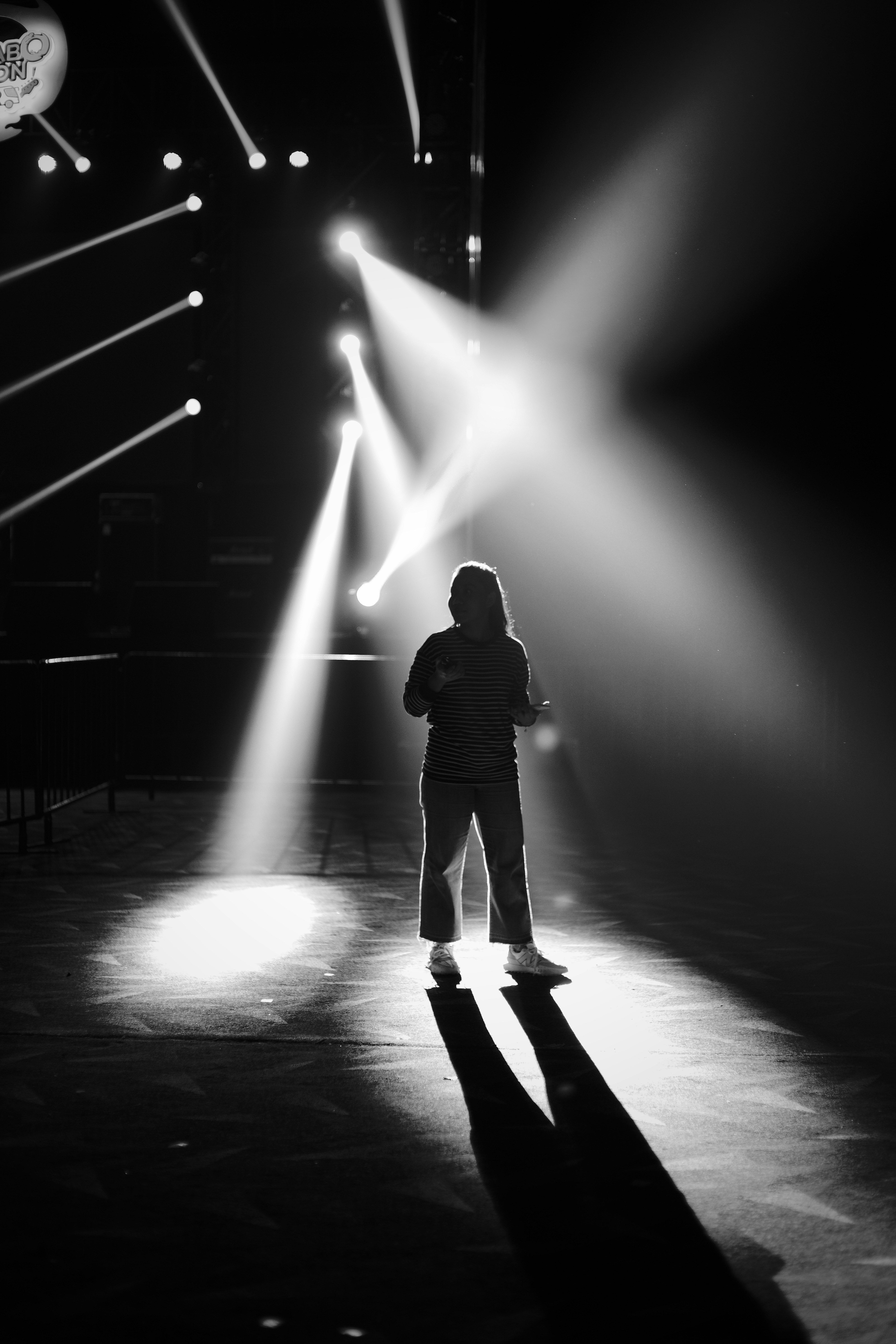 스포트라이트 아래 서 있는 여성 참가자 관련 사진