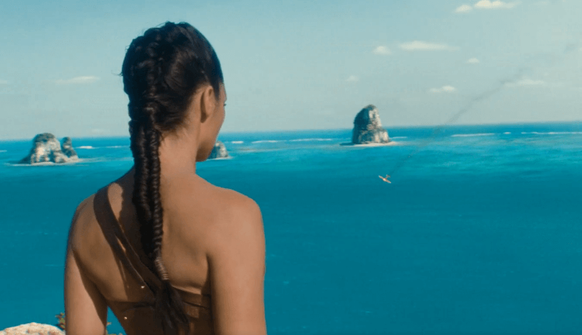Diana of Wonder Woman is on the beach watching a plane crash into the sea.