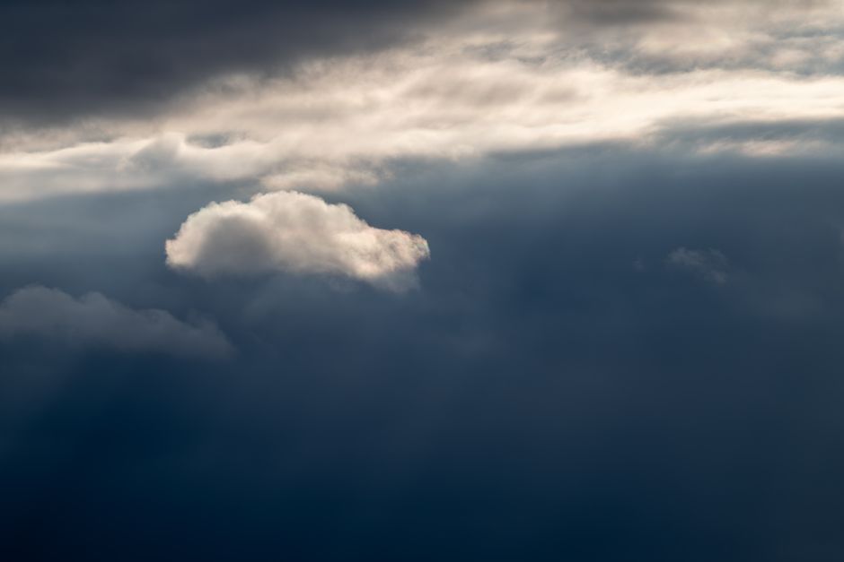 Serene cloudscape with sunlight rays piercing through dramatic clouds. A peaceful sky study.