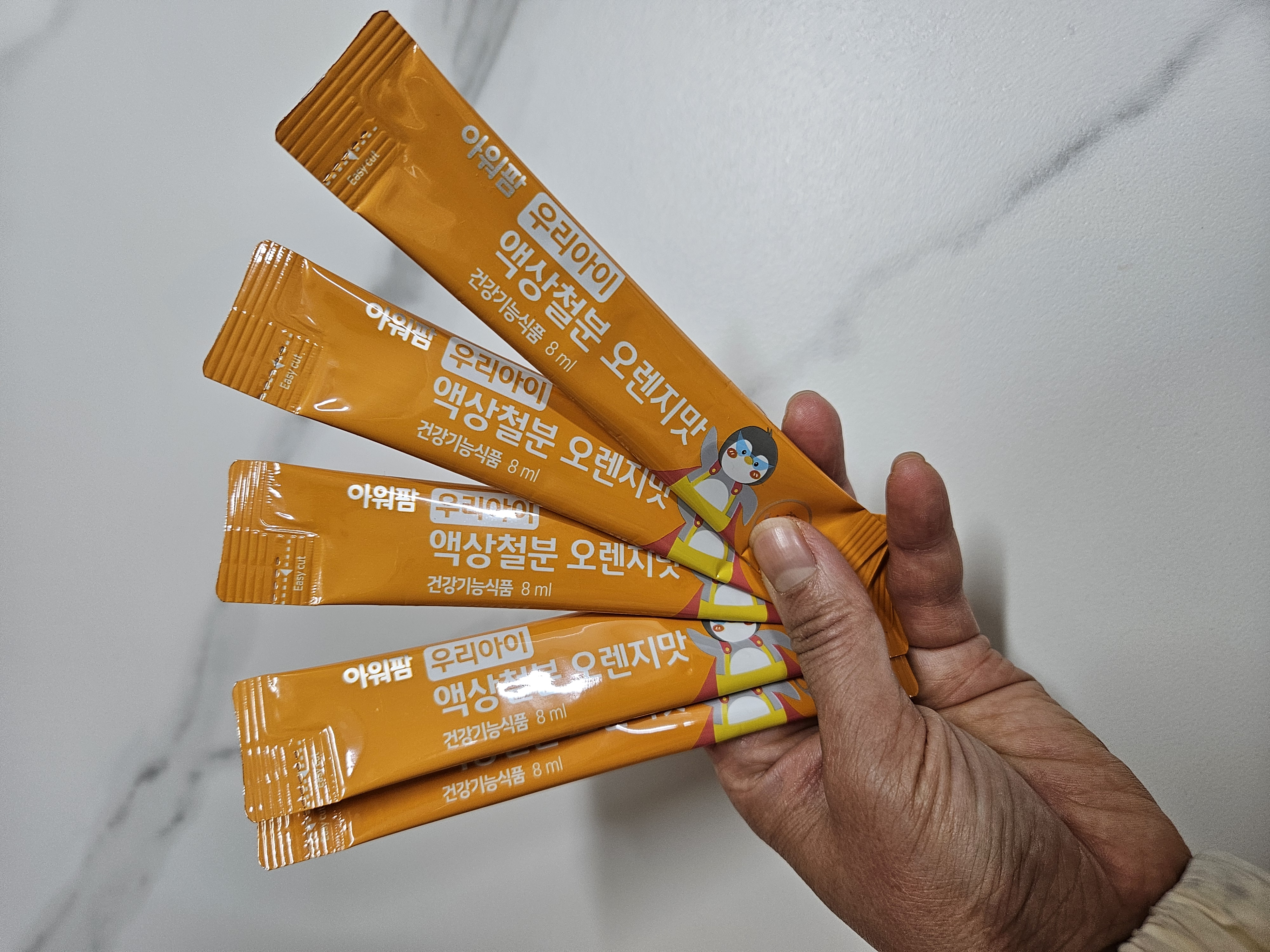 손으로 쥐고 이쓴ㄴ 아워팜 우리아이 액상철분 오렌지맛 스틱