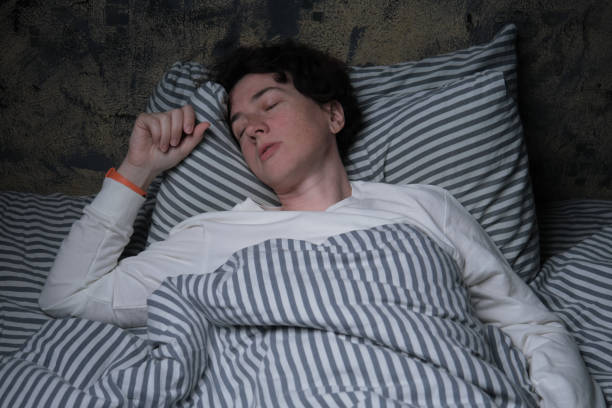 침대에 누워 있지만 쉽게 잠들지 못하는 사람