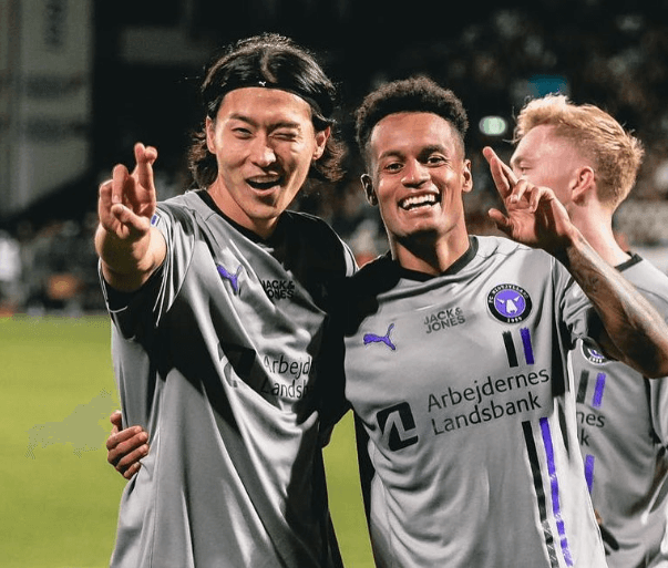 조규성 선수가 동료와 함께 경기장에서 세레모니하는 장면