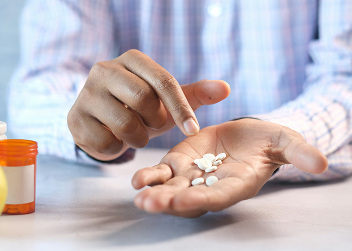 손바닥에 있는 약을 손으로 가르키고 있다