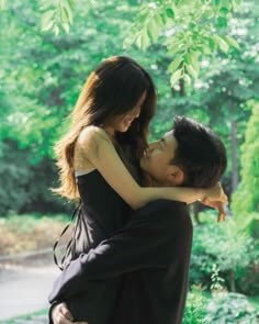 푸르른-숲속에서-검은-원피스를-입은-여성을-번쩍들고있는-남자