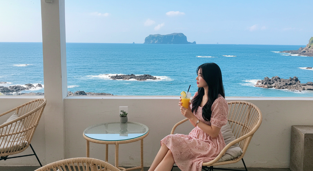 제주 바다 전망 카페에서 느긋하게 휴식하는 한국인 여성