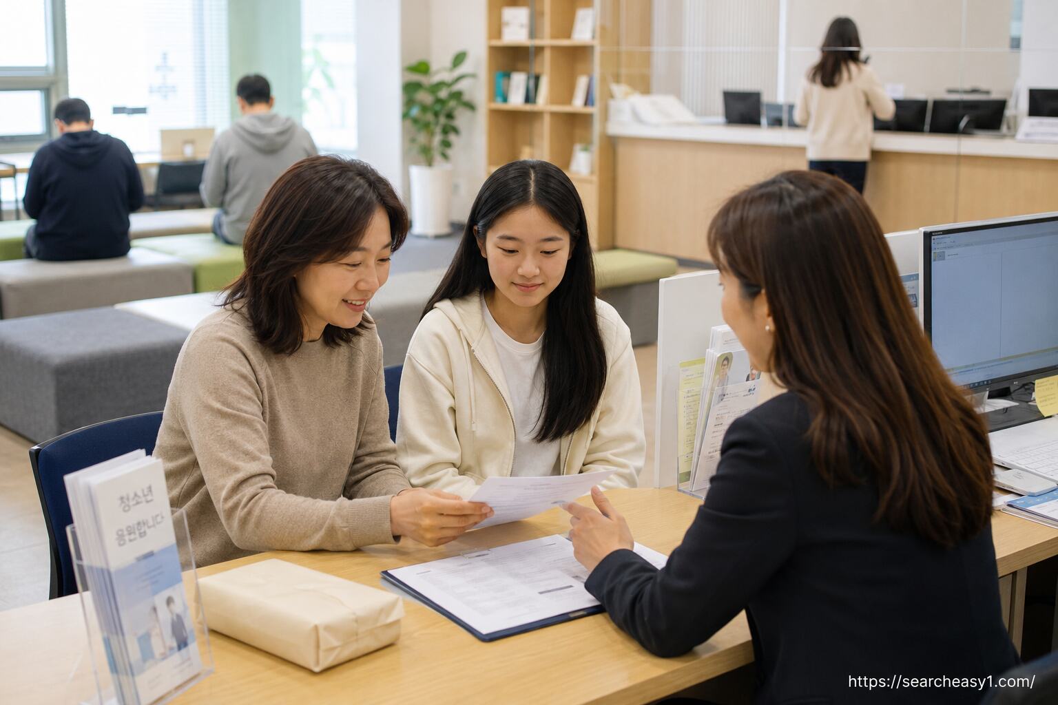 부모와 여성청소년이 청소년 지원 상담창구에서 생리용품 지원 신청서를 확인하는 모습