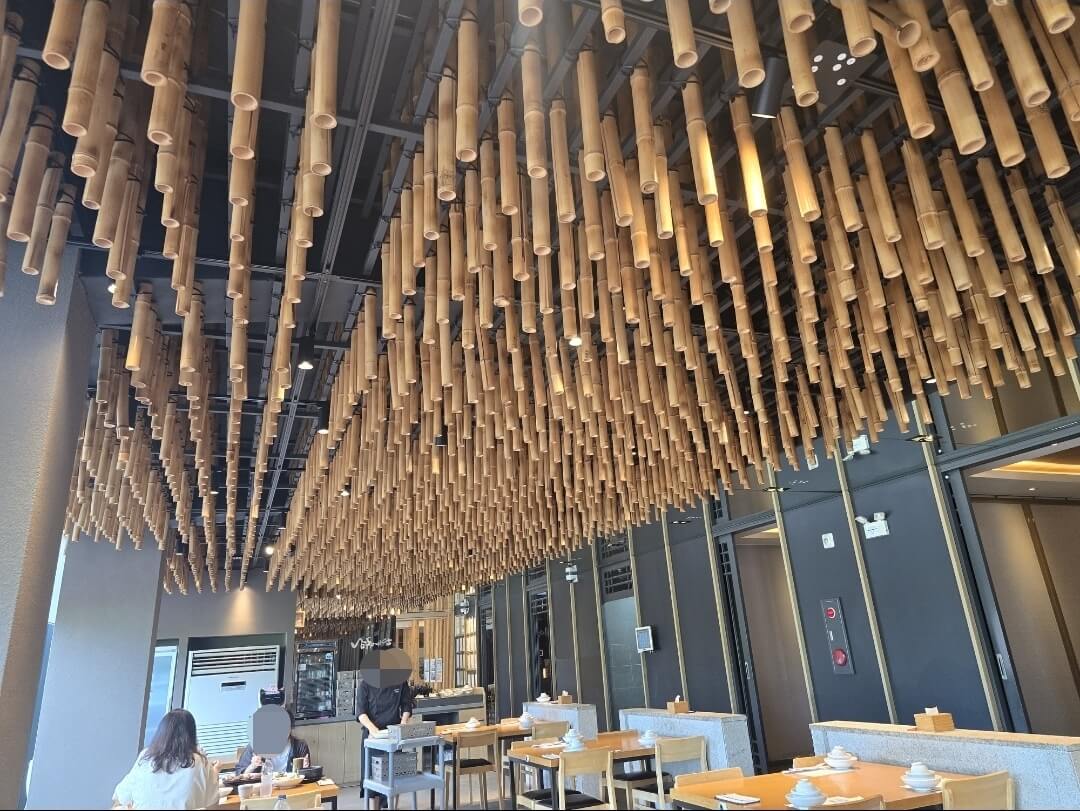 식당내부 2 명이 식사를 하고 있고 종업원이 음식을 나르고 있다