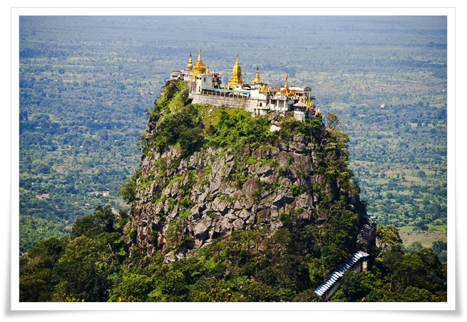 평원에 우뚝 솟아있는 산의 정상에 뽀쪽한 금색 지붕의 흰색 건물 수도원이 경이로움을 느끼게 한다