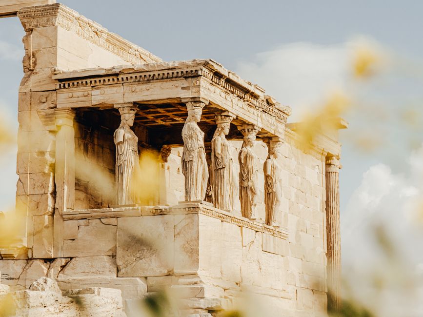 The iconic Caryatids of the Erechtheion temple, highlighted against a bright sky.