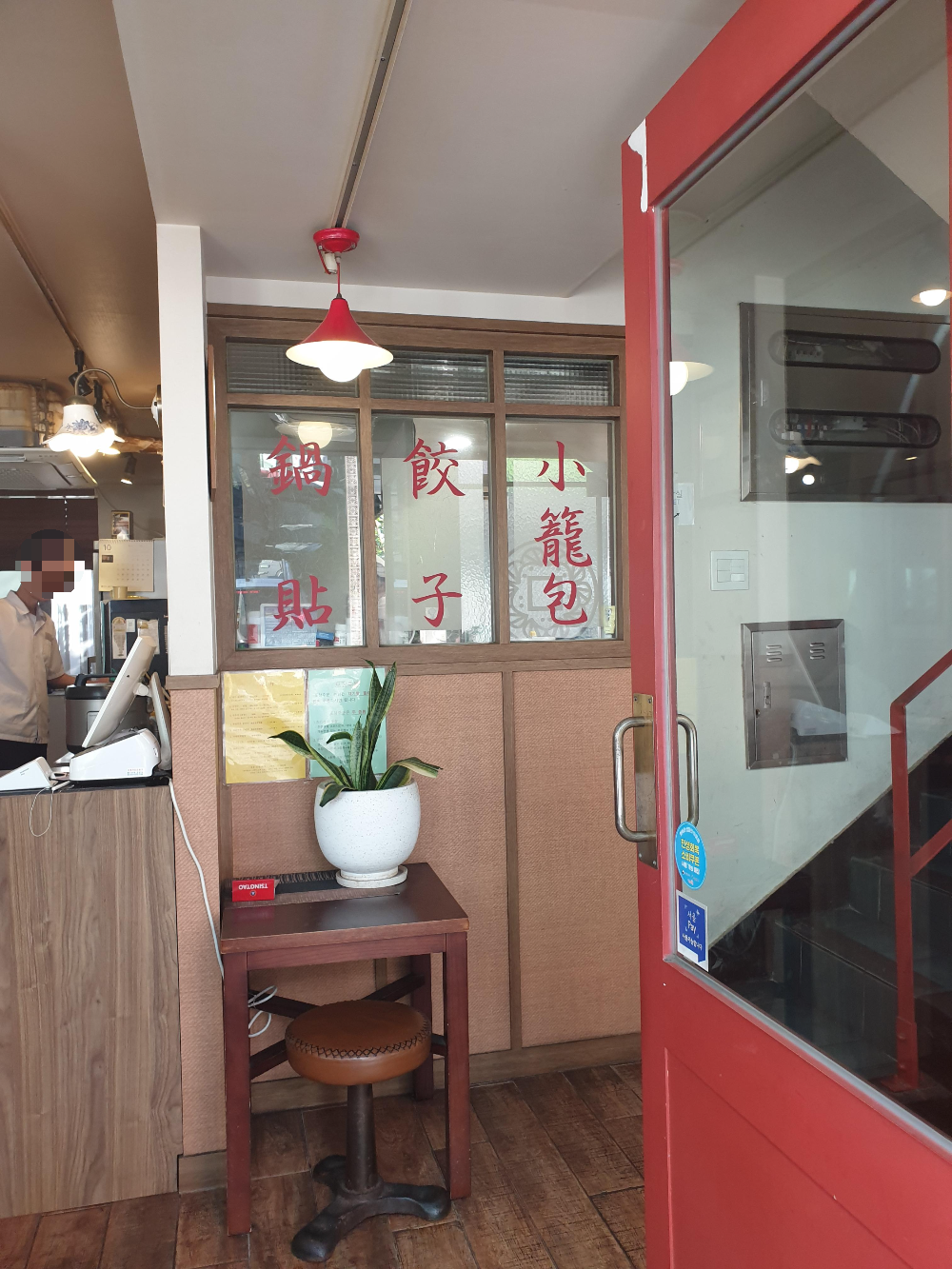 1층 입구에 한자로 메뉴들이 적혀있다. 2층으로 가는 계단이 우측에 보인다.