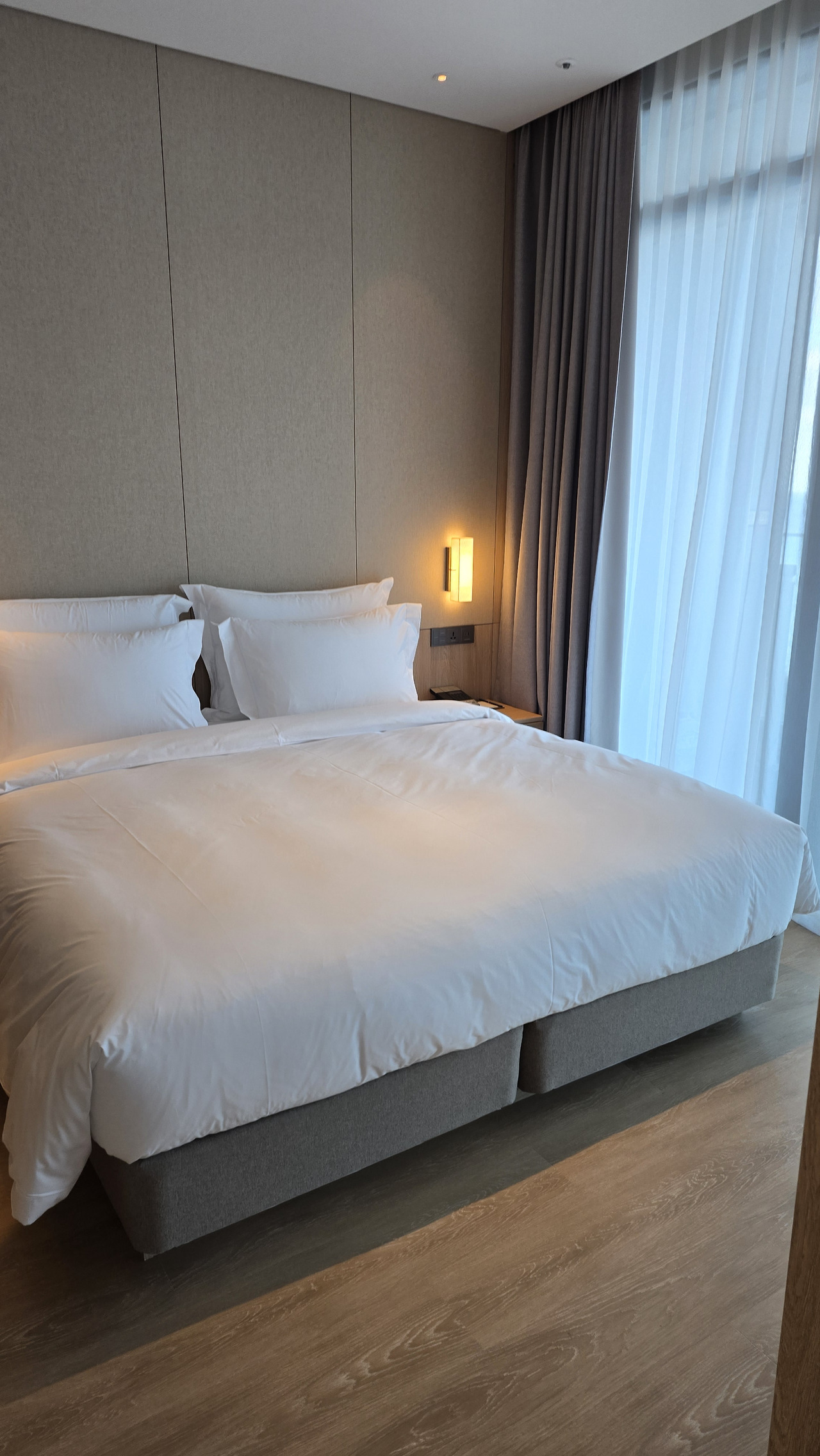 신라 모노그램 호텔 객실 중앙에 놓인 푹신한 침대와 우드 포인트 가구