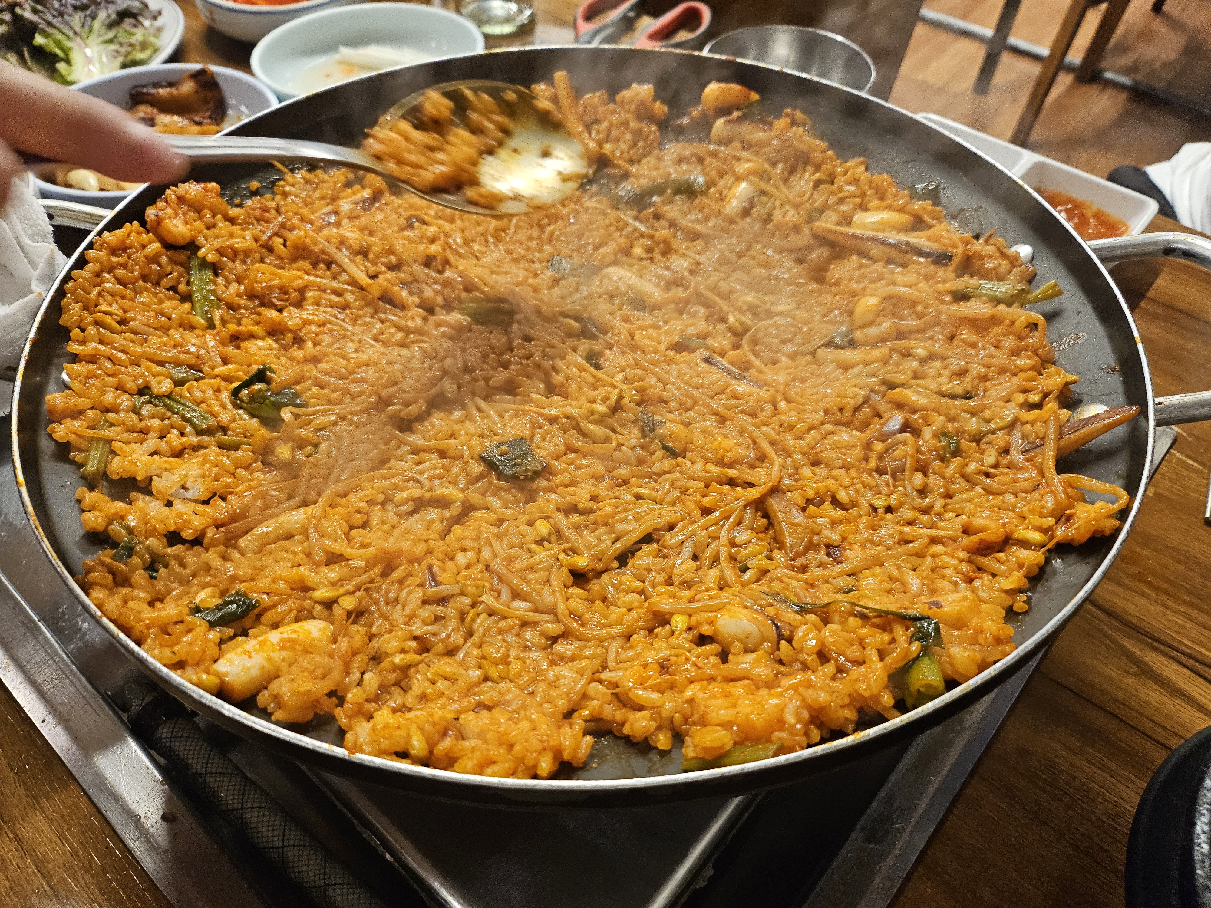 오징어불고기 양념에 맛있게 볶아진 볶음밥, 숟가락으로 밥을 뜨고 있다.
