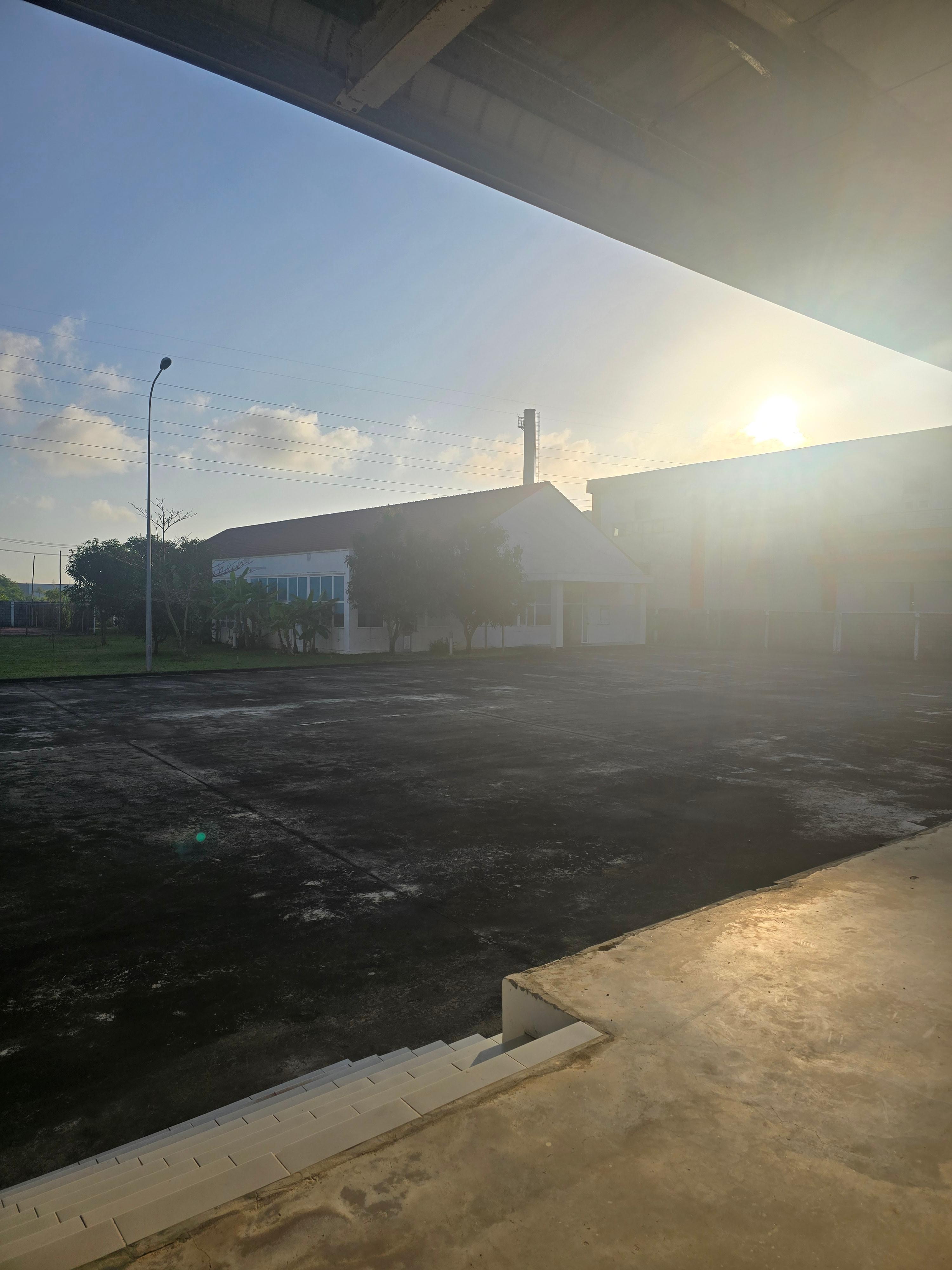 베트남 공장 숙소 전경, 이른 아침 햇살이 비추는 작업 전 마당