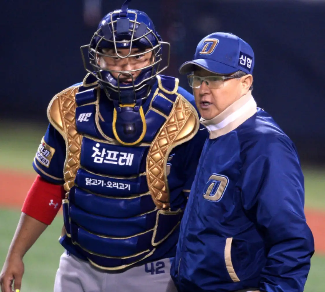 파란 야구점퍼를 입은 김경문 감독과 그옆 파란 보호복을 입은 포수