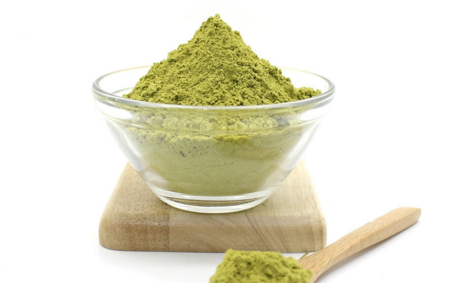 솔잎을 깨끗하게 세척한 후에 바싹 말린 후에 잘게 가루 낸 것을 가득 담은 투명한 유리 그릇과 나무 숟가락을 하얀 바닥 위에 나무 도마를 두고 그 위에 놓아두고 찍은 사진