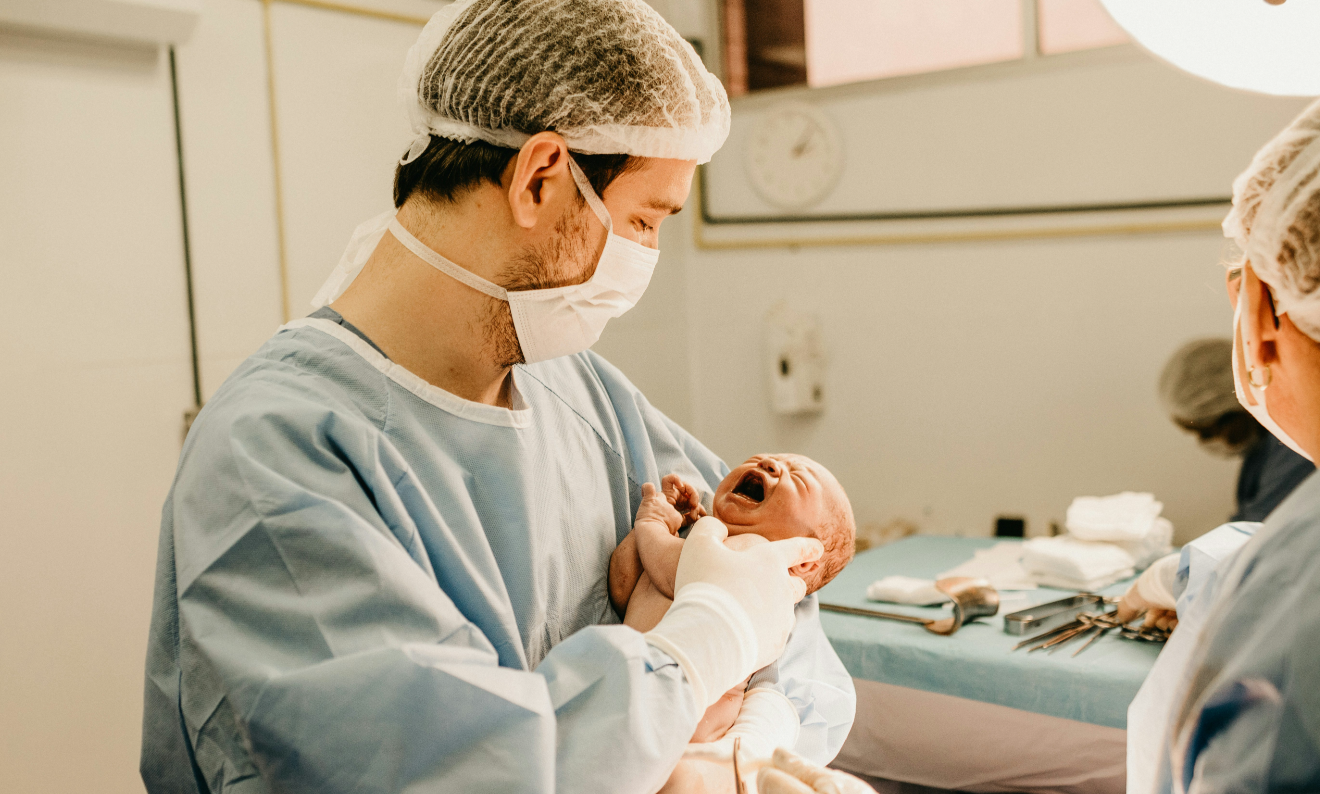 분만실에서 신생아를 안고 있는 남성