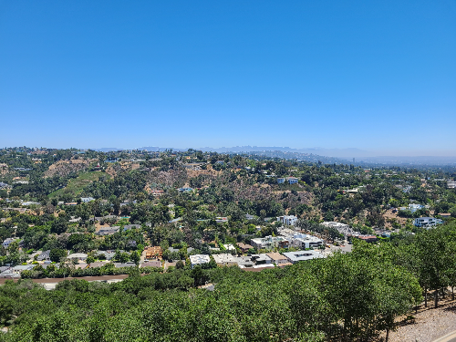 게티 센터에서 바라본 풍경 1. 가까운 쪽부터 먼 쪽까지 나무와 도로, 낮은 건물들, 언덕 위의 나무 순서로 보인다.
