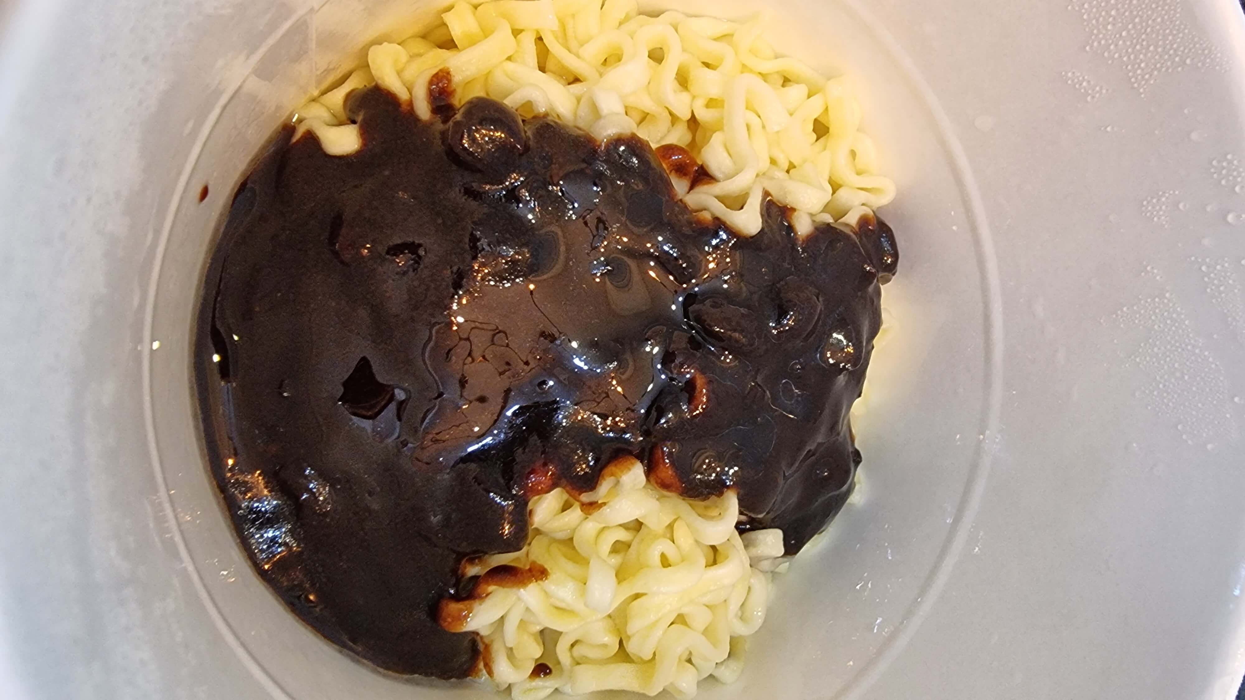 짜장 컵라면에 액상스프를 넣고 먹을 준비를 하고 있다