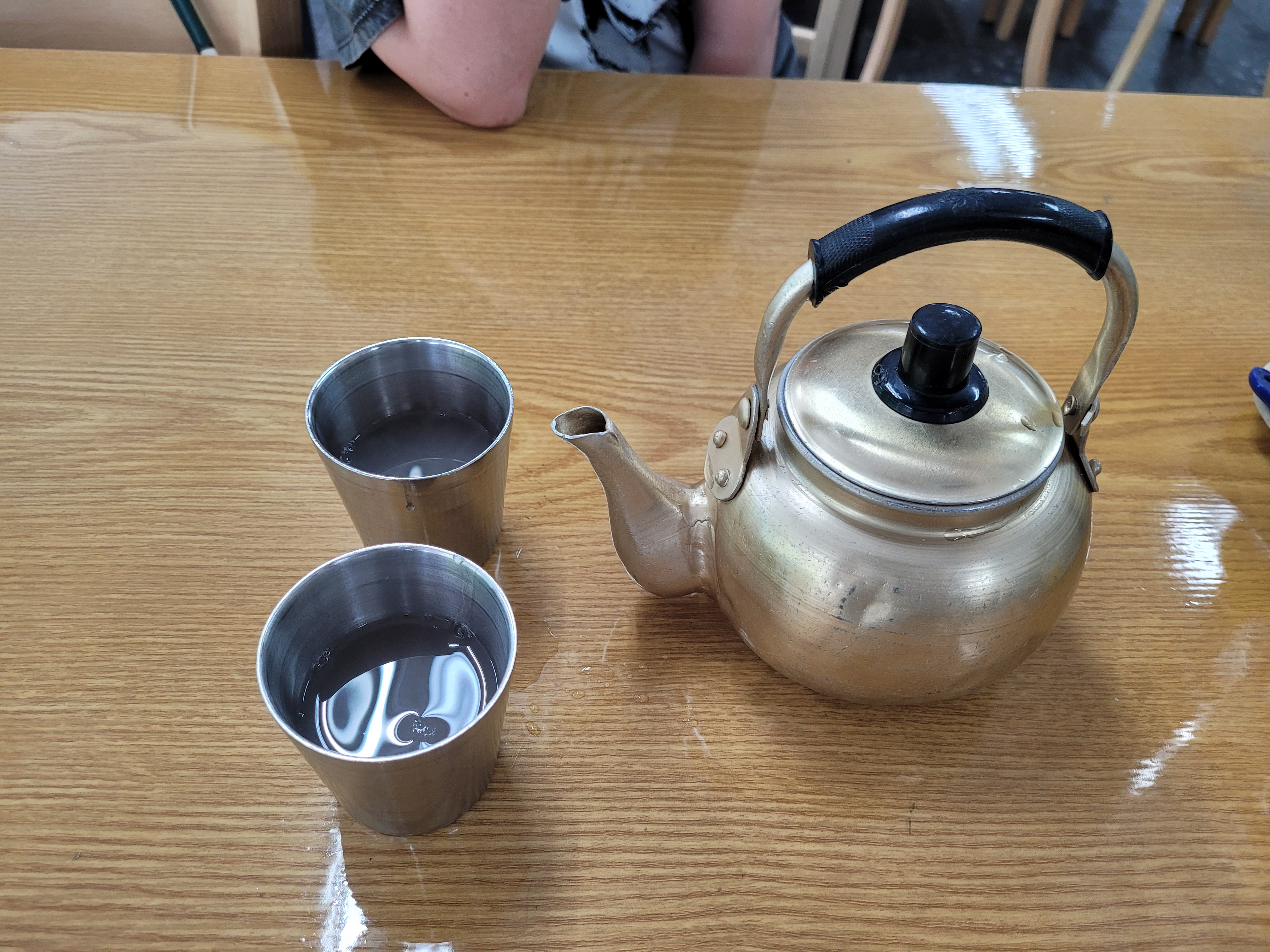 메밀 국수 끓인물이 담긴 주전자와 스테인리스 컵