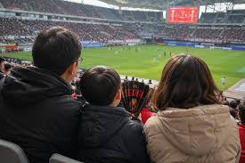 부모가 아이와 함께 축구를 보며 대화하는 모습