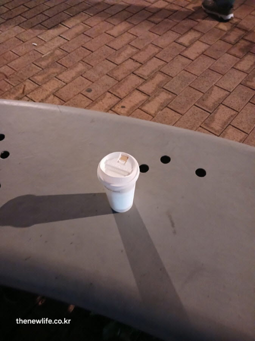 밤거리 벤치 위에 놓인 블랙커피 한 잔, 간 건강과 해독 작용을 상징하는 여유로운 장면