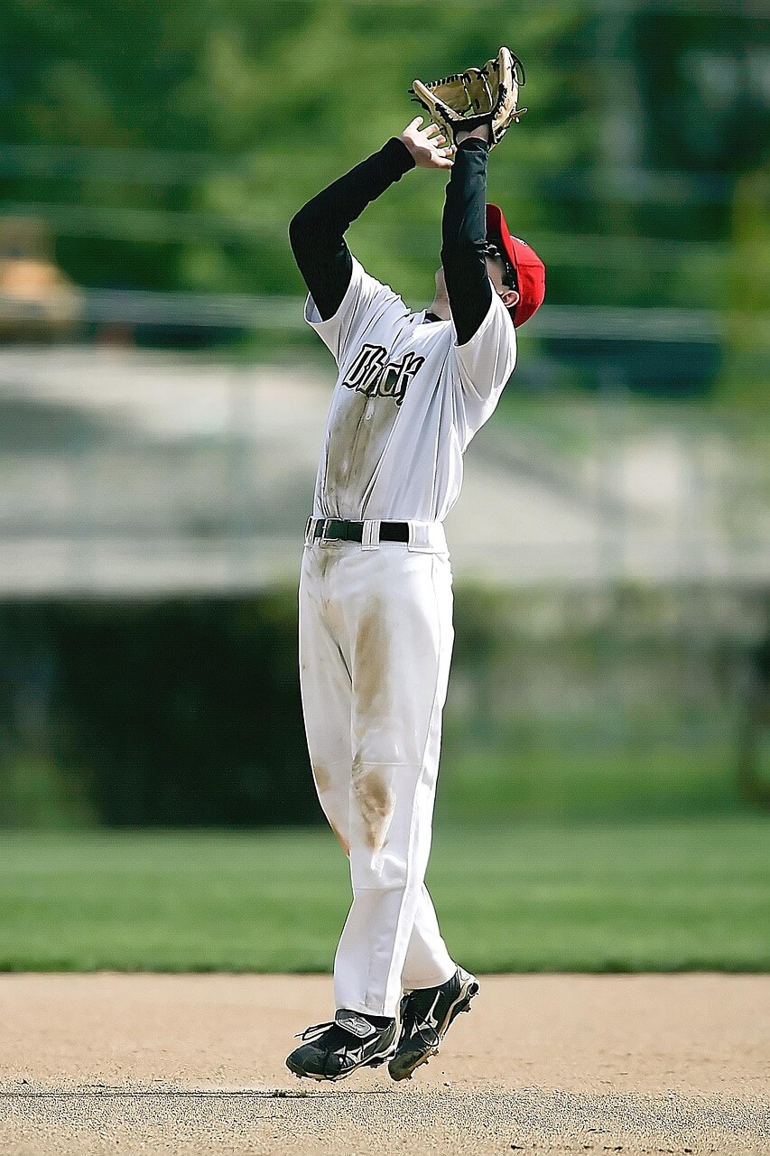 Side-by-side comparison of muddy youth baseball pants and clean white pants after treatment.