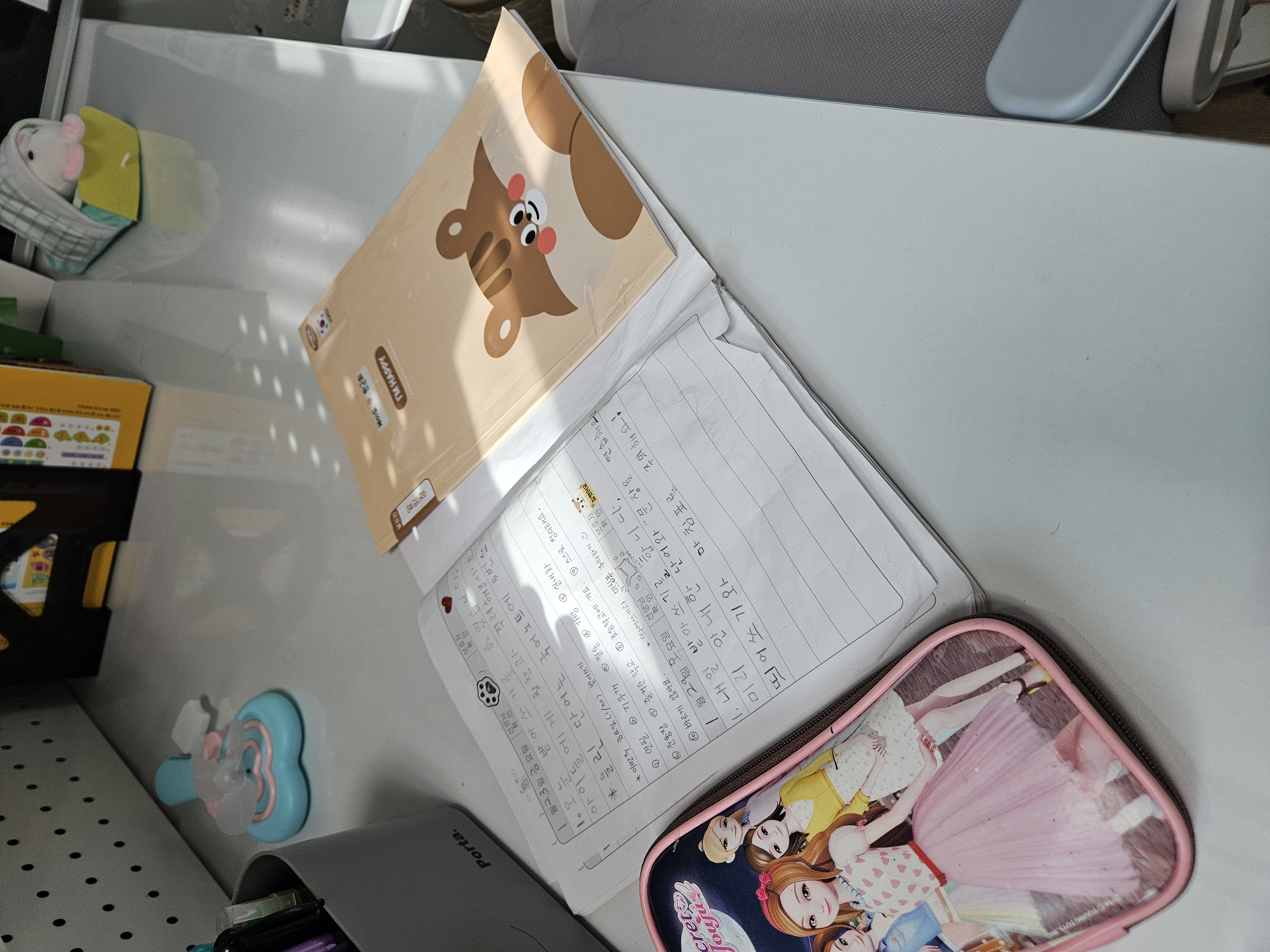 책상 위에 펼쳐진 알림장과 공부방 교재가 놓여진 모습