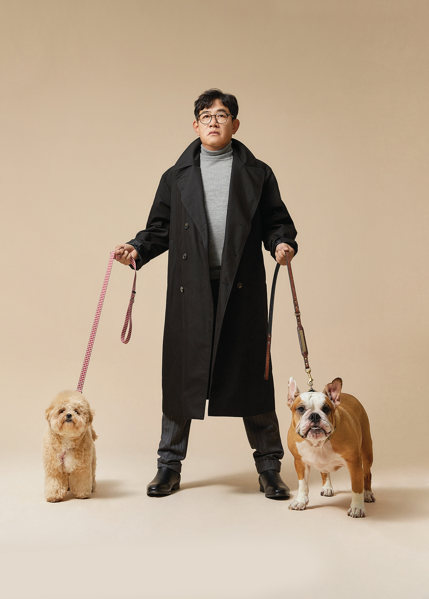 약물 운전으로 논란이 된 개그맨 이경규씨가 검은 코트 차림에 강아지 두 마리를 데리고 서있는 모습