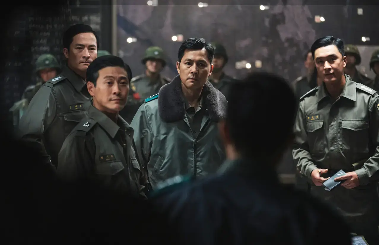 군인들과 함께 있는 이태신이 상대방을 뚫어지게 바라보는 모습